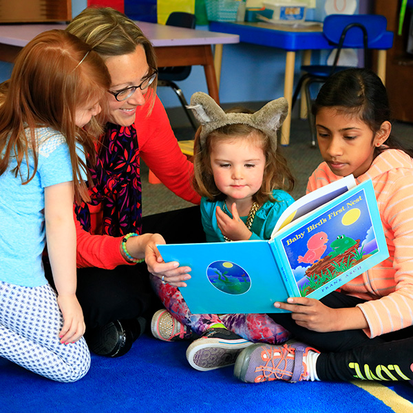 Young students reading with teacher